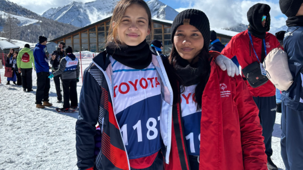 Emily Salguero Mata (left) and Ashly Sanchez Ledezma (right) stand together smiling after a successful completion of 100m Snowshoeing Divisioning.