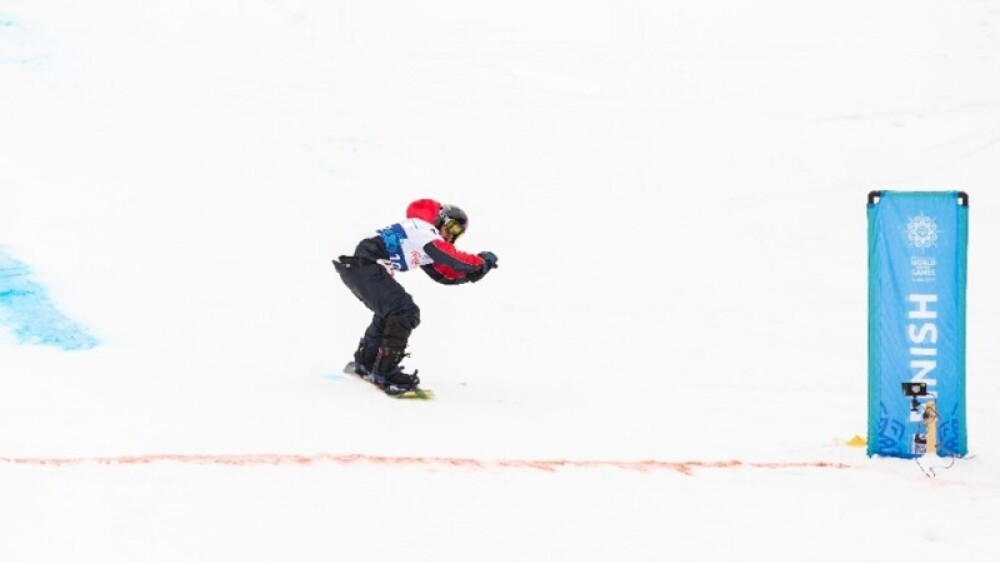 Gonzalo Escobar from Special Olympics Chile crossing the finish line of the Advanced Giant Slalom Snowboarding Final.